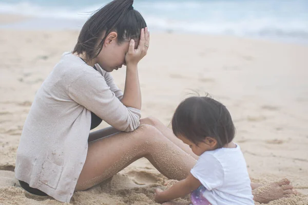 Kızı kumsalda kumsalda oynarken hayal kırıklığına uğramış anne strese girdi. — Stok fotoğraf