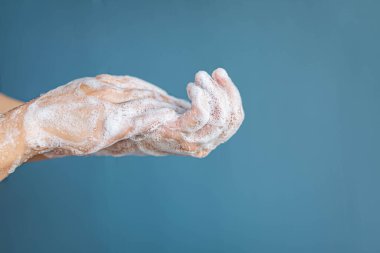 Ellerin sabunla ovalanması ve suyun mavi bir siyah zemin ile ovalanması..