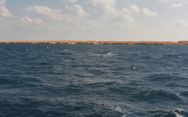 Güzel manzara Kızıldeniz Hurgada yakınındaki adada sahil şeridi üzerinde. Deniz manzarası arka plan beyaz bulutlar ile.