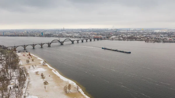 Aerial view from drone on railway bridge above Monastic island and Dnieper river in Dnipro city. Winter landscape and cityscape background. (Dnepr, Dnepropetrovsk, Dnipropetrovsk)