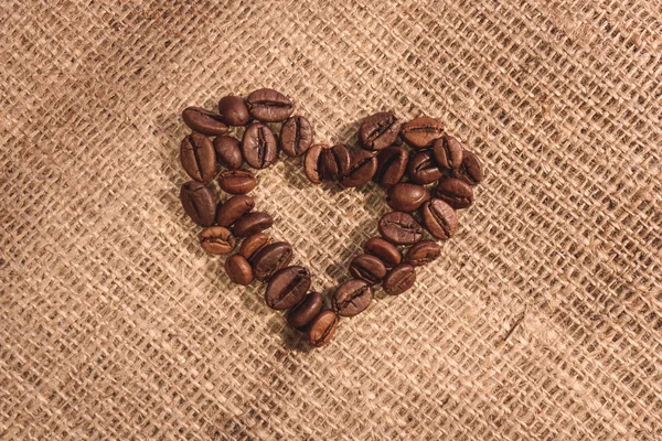 Kształt Serca Naturalny Brązowy Palonych Ziaren Kawy Płótnie Tkanina Tło — Zdjęcie stockowe