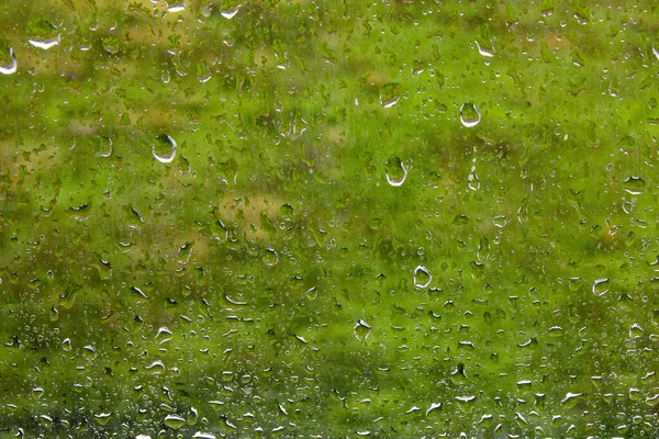 Close-up of water drops on glass. Heavy rain outside the window. Rainy weather background.