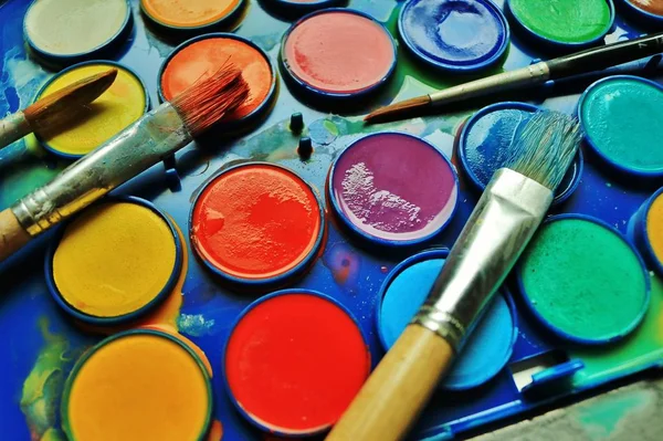 Sanat dersi gelen kirli fırçalar ile dağınık kullanılan suluboya