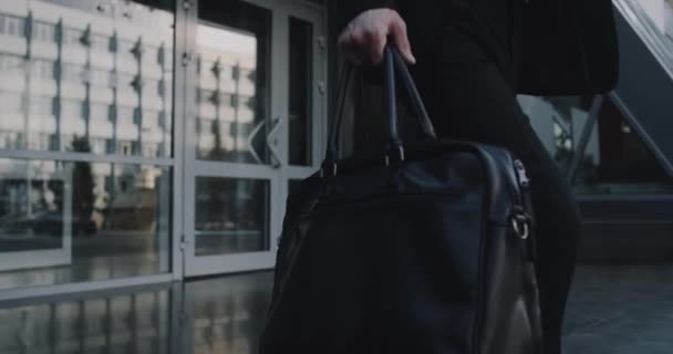 Торговец крупным планом идет в бизнес-центр с портфелем в руках. — стоковое видео