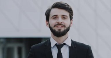 Closeup şık ekmek kamera önünde gülümseyen elbiseli Genç adam. 4k