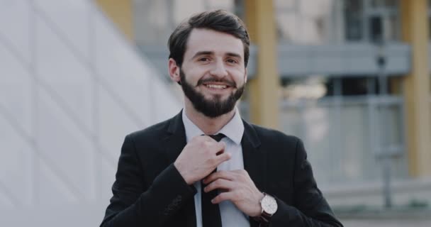 Νέος επιχειρηματίας με ένα ωραίο πηγούνι κανονίσει γραβάτα του, μπροστά από την κάμερα — Αρχείο Βίντεο