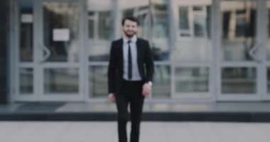 Yakışıklı işadamı kamera düz-e doğru ve güzel gülümseyen kameraya bakarak ile yürüme