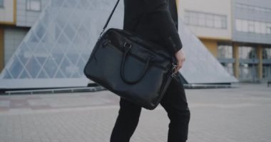 Evrak çantası ile işe gitmeye closeup genç adam. Kırmızı destan. 4k