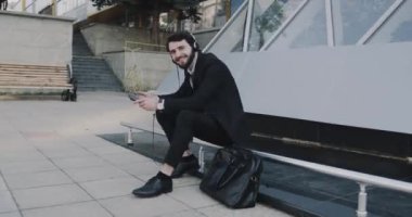 Mutlu ve işadamı dinlemek müzik dans ve modern iş merkezi önünde onun telefon tutarak. Kırmızı epik