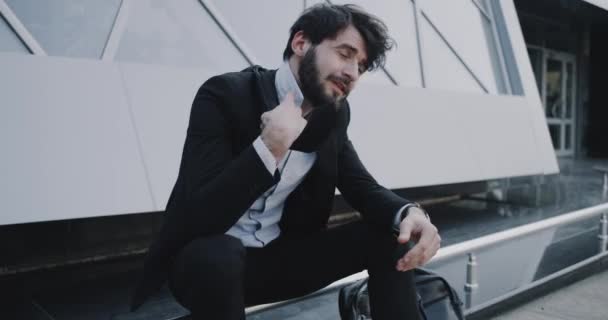 Nervous business man get his tie out after his get interviewed in front of the business office — Stock Video