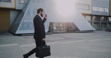 Modern iş merkezi yürüyüş bir siyah güneş gözlüğü ile bir takım elbise çok şık genç adam