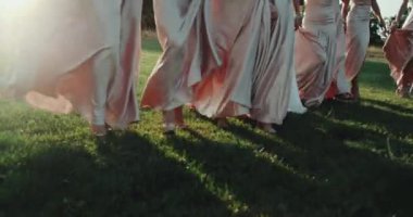 Kızlar çimenlerin üzerinde yürüyüş Closeup uzun elbise giymiş