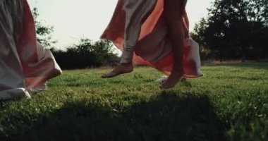 Çimenlerin üzerinde daire dans ve uzun pembe elbise giymiş harika kızlar