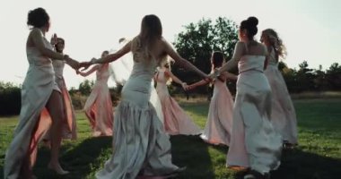 Muhteşem gelin ve şaşırtıcı güneş ışığı ile çimenlerin üzerinde inanılmaz dans onun nedime. Kırmızı epik