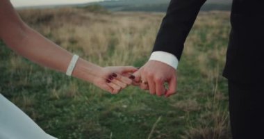 Closeup gelin ve damat onların elele ve yürüyüş.