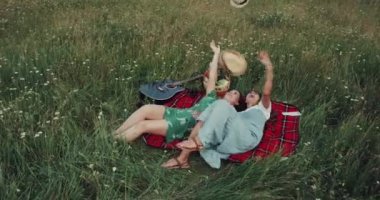 Battaniye var bırakmasını ve şapkalar atmadan güzel genç kız piknikte,