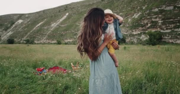 Niño bonito con una hermosa sonrisa diviértete con su madre en medio del paisaje . — Vídeos de Stock
