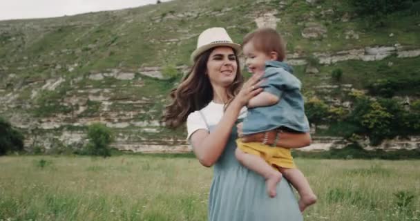 Madre che gioca con il suo bambino sorridente in mezzo alla natura . — Video Stock