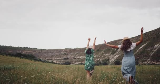 Running two girls in the middle of grass field — Stock Video