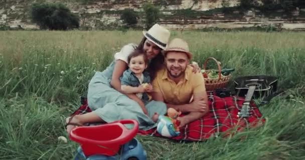 Bonita familia, en el picnic jugando con ellos bebé, tienen una cara sonriente. 4k — Vídeo de stock