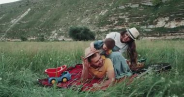 Annem ve babam piknik manzara ortasında bir bebek çocuklarla oynarken