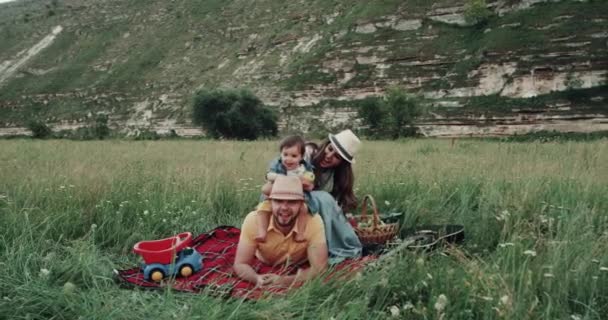 Smiling beautiful family at the picnic playing, in the middle of mountain — стоковое видео