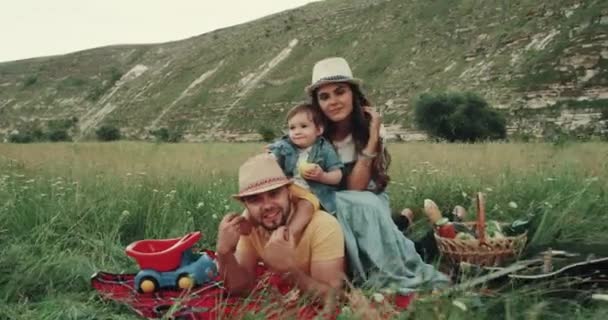 Bonita familia en el picnic emociones mirando a la cámara sonriendo y tener una cara feliz — Vídeos de Stock