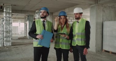 Çalışma alanı iki erkek ve bir dişi inşaat alanında iş planını kontrol edin. 4k