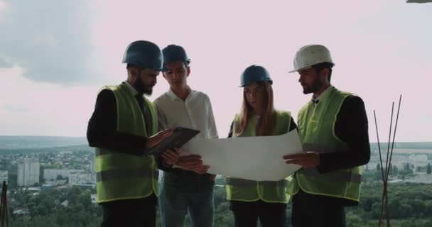 Four young engineers and architects team analyzing the project of building. — Stock Video