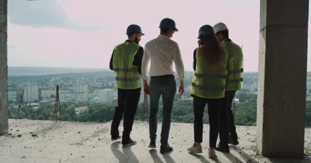 Groep van ingenieurs die het analyseren van de kaart van de bouwplaats — Stockvideo