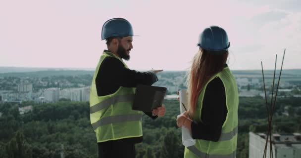 Dos jóvenes empresarios y un ingeniero experto discuten sobre el siguiente sitio de construcción, hacen mucho al final tomados de la mano. 4k — Vídeos de Stock