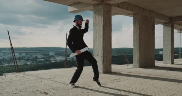 Giovane ingegnere ballerino dopo il lavoro sul tetto in cantiere . — Video Stock