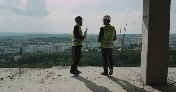 En affärsman visar sin byggarbetsplats och diskutera med sin partner, hålla händerna. — Stockvideo