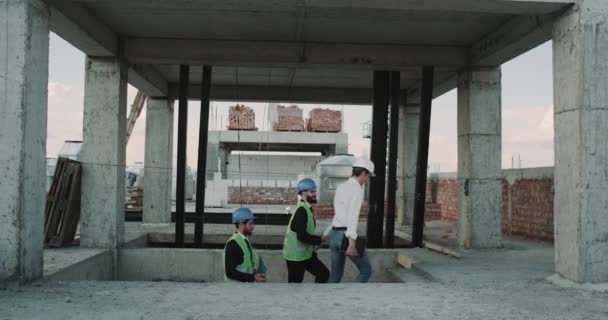 Μηχανικός και αρχιτέκτονας έρχονται σε ταράτσα κτιρίου βλέπουν την κατασκευή κτιρίων — Αρχείο Βίντεο