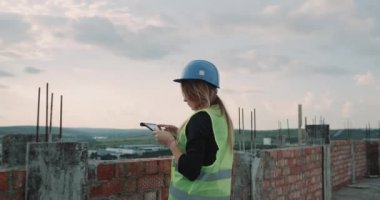 Kadın uzman mühendis ve inşaatçılar tablet kullanarak bina inşaat planı analiz grubu