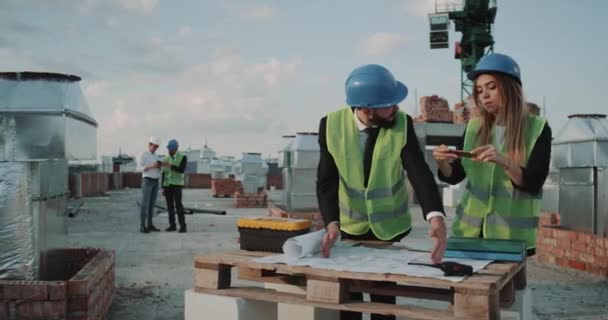 Teamwork van ingenieurs die het analyseren van de kaart van de bouwplaats met behulp van een tablet. — Stockvideo