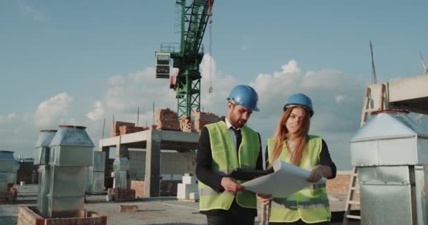 Twee partners van de bouw, het analyseren van de kaart van nieuwe appartementen gebouw, op zoek geconcentreerd door middel van de bladen. — Stockvideo