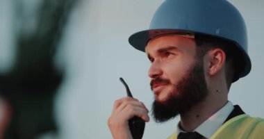 Bir radyo kullanarak ve bir kask giyiyor Closeup konuşan işadamı.