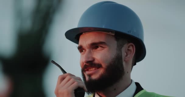 Mycket närbild talar på radio ung ingenjör bära skyddshjälm. — Stockvideo