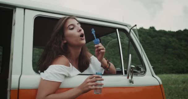 Девушка с брекетами, пускающая голубые пузыри. 4k — стоковое видео