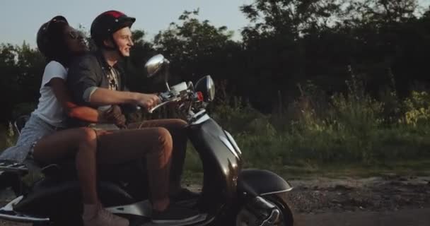 On the road a cute couple are riding a bike are smiling and having a lot of fun — Stock Video