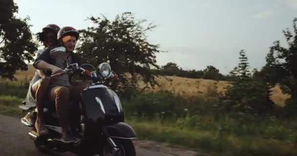Na estrada, um casal bonito está andando de bicicleta com seus capacetes em todos felizes e alegres. movimentos lentos — Vídeo de Stock