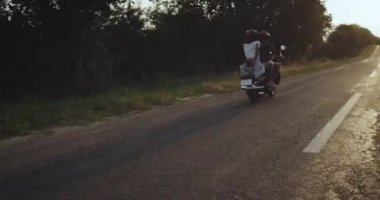 Neşeli mutlu INLOVE birkaç güzel parlak gün batımı manzaralı bir motosiklet sürme
