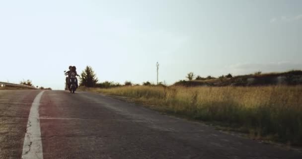 Una giovane donna e un uomo stanno guidando la loro moto sulla strada — Video Stock