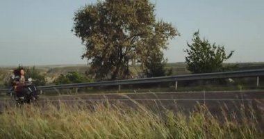 Çift kız sinsice içinde alan manzaralı kolunu hareket geçmiş poz motosiklet sürme iken