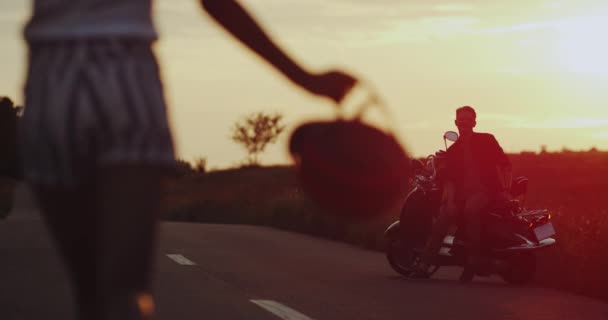 Kör afrikansk flicka på mitten av vägen till hennes pojkvän som väntar henne på sin motorcykel, hålla varandra. — Stockvideo