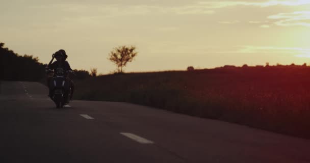 Молода пара їздить з дивовижним ретро мотоциклом на дорозі з дивовижним заходом сонця. повільні рухи — стокове відео
