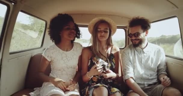 Vintage retro stylish friends two young women and a guy in a bus on the way looking through the window smiling. 4k Royalty Free Stock Footage