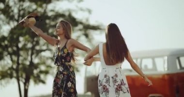 Uzun saç ortasında şık bir retro elbiseyle doğa mutlu dans ile genç ve güzel bayanlar.