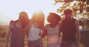 İki genç erkek ve iki genç kadın birbirlerini çok kültürlü insanlar, bir arada tutan yürüyüş gülümseyen ve iyi bir ruh hali var. 4k